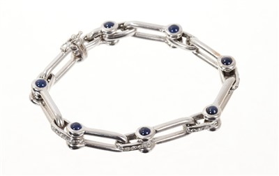 Lot 718 - 18ct white gold bracelet with stirrup links, cabochon sapphire terminals and diamond set spacers.