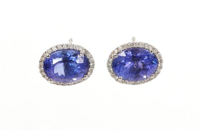 Lot 617 - Pair of tanzanite and diamond cluster earrings, each with an oval mixed cut tanzanite surrounded by a border of brilliant cut diamonds in white gold setting. Tanzanites estimated to weigh approxima...