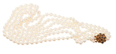 Lot 643 - Cultured pearl three-strand necklace with three strings of graduated cultured pearls measuring 6.0 to 9.3mm in diameter, on a sapphire and gold bombe clasp.