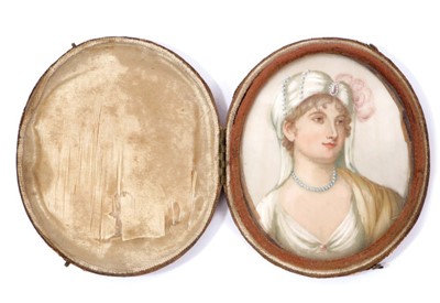 Lot 1236 - English School, circa 1795, miniature watercolour portrait on ivory, depicting a young lady wearing a turban and pearls, oval 7 x 6cm, in glazed folding red leather case