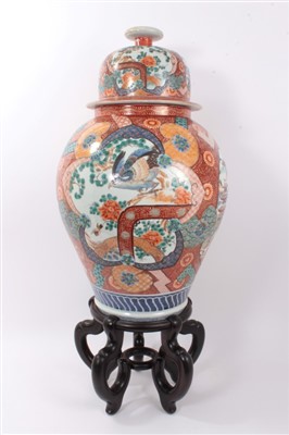 Lot 362 - Large late 19th/early 20th century Japanese Arita porcelain vase and domed cover , with eagle and landscape reserves on gilt and orange floral scroll ground 64cm with hardwood stand (2)