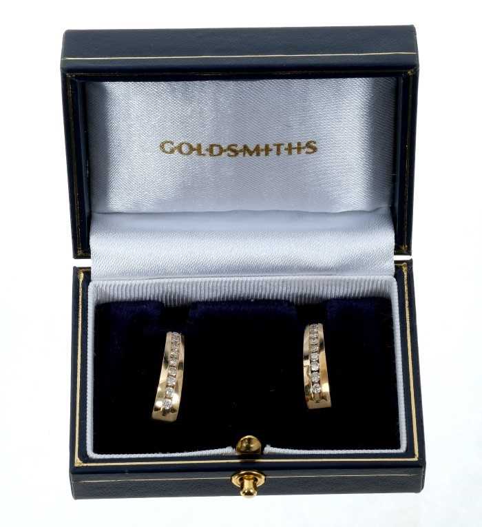 Lot 87 - Pair of  14ct gold and diamond hoop earrings, each with a line of channel set brilliant cut diamonds estimated to weigh approximately 1 carat in total. 21mm