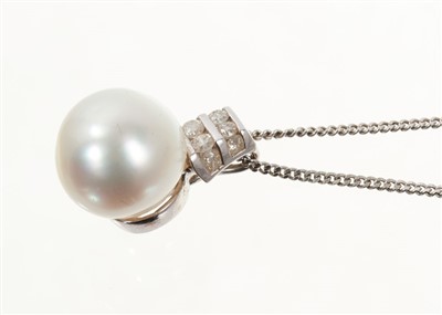 Lot 710 - Cultured freshwater pearl and diamond pendant with a 12.8mm diameter cultured pearl in 18ct white gold mount with channel set diamonds, on a 9ct white gold chain.