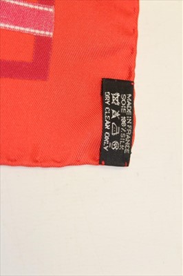 Lot 3121 - Hermes red silk scarf 1983 'Bolduc' designer Jean-Louis Dumas and Hermes gilt metal scarf ring, both boxed