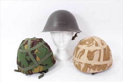 Lot 621 - Group of three military helmets, to include a 1950's tin helmet, and two Kevlar helmets with camoflague coverings (3)