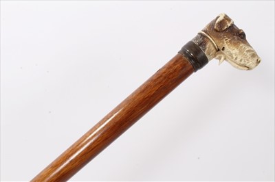 Lot 3688 - Late 19th century/early 20th century glove stick with metal collar surmounted by a composite handle in the form of a dog's head with sprung mouth and glass eyes, 89cm overall length