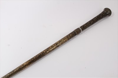 Lot 3689 - Early 20th century heavy metal walking stick with raised Nielloware style decoration and wiggle work ferrule, 90.5cm overall length