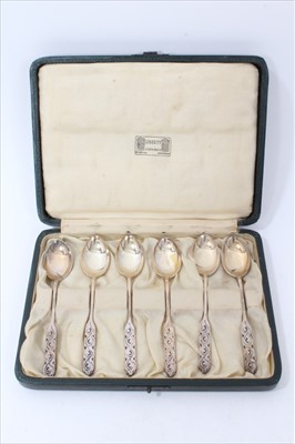 Lot 3405 - Set of six Liberty silver tea spoons with cast scroll to the handles. Maker’s mark for Liberty and hallmarked London 1926 in original fitted case.