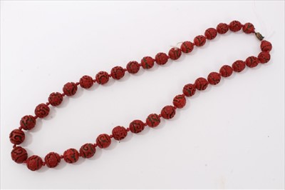 Lot 3485 - Chinese cinnabar lacquer bead necklace with 14mm-17mm diameter spherical red lacquer beads, on Chinese silver clasp.