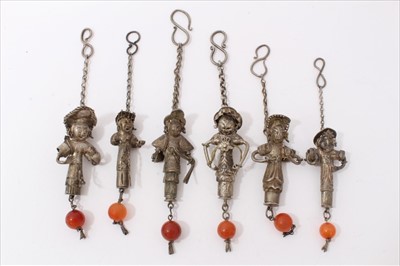 Lot 3495 - Six old Chinese white metal pendants, each modelled as a figure, suspending a carnelian bead