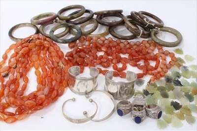 Lot 3497 - Group of jewellery to include Chinese green stone bangles, four white metal and lapis lazuli dress rings, carnelian bead necklaces, carved green stone fish etc