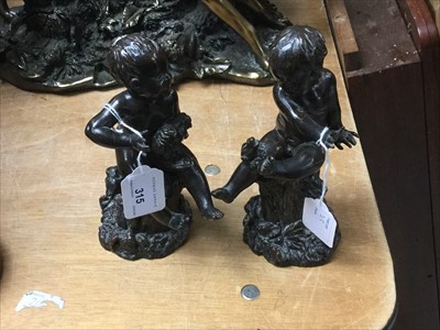 Lot 315 - Pair of bronzed figures of babies sitting on stumps