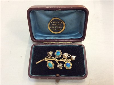 Lot 674 - Gold (stamped 10K) floral spray opal set brooch, boxed