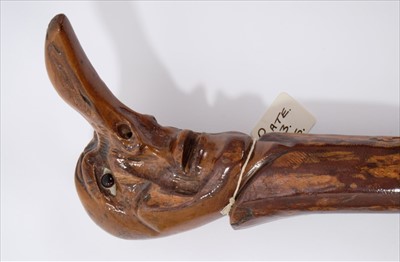 Lot 686 - Rare carved wood 'grotesque' walking stick, the terminal carved with stylised head with protruding nose, 94cm