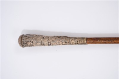 Lot 696 - 19th century Anglo-Indian white metal mounted walking stick, the gently tapering handle embossed with deity figures, tapering wooden shaft with brass ferrule, 80cm long