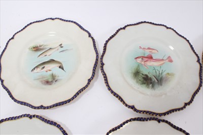 Lot 50 - Late Victorian Royal Worcester porcelain fish service, each piece with overpainted transfer decoration depicting various fishes and gilded cobalt blue gadrooned edging  - comprising twelve plates,...