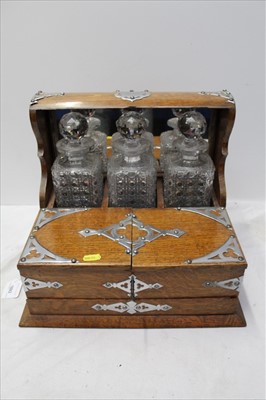 Lot 1893 - Edwardian Oak three bottle tantalus with chromium plated fittings