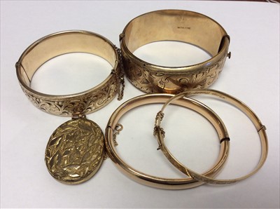 Lot 651 - Four gold plated bangles and a gilt oval locket