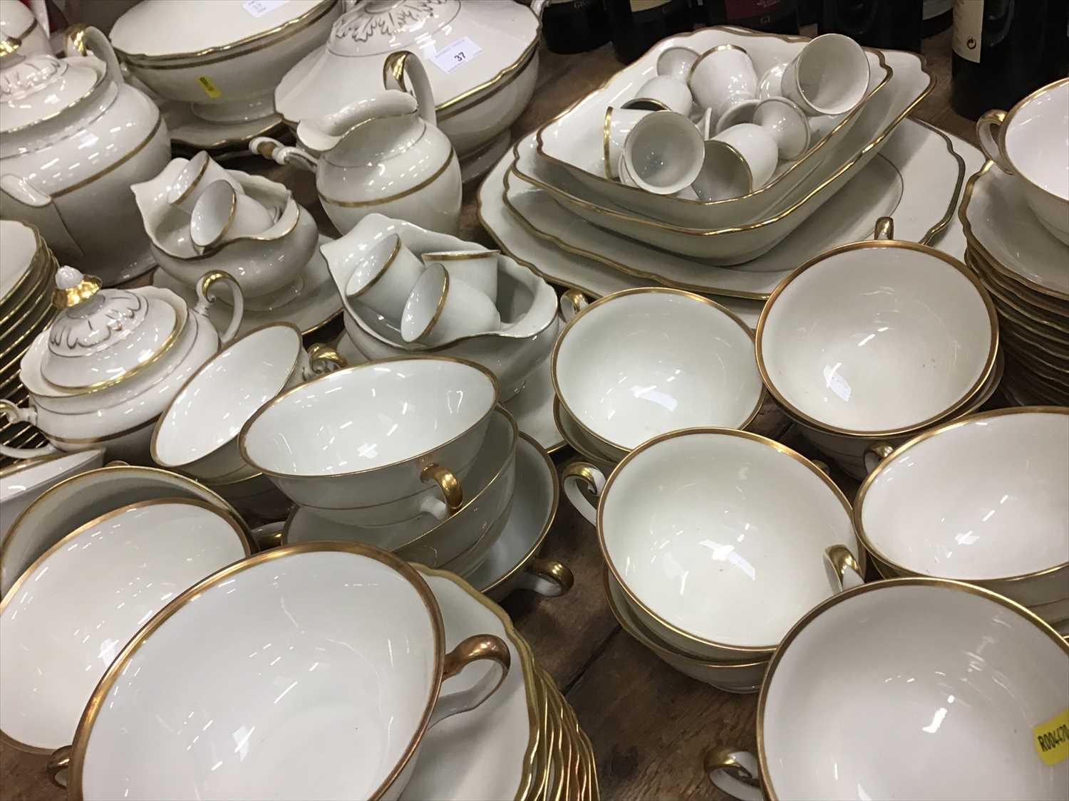 Lot 37 - An extensive German twelve place setting dinner and tea service with gold rims on cream ground