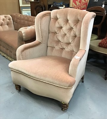 Lot 947 - Victorian wing back chair upholstered in beige buttoned material on turned front legs