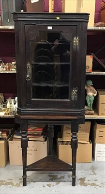 Lot 940 - Antique oak corner cupboard on stand with glazed door above enclosing shaped shelves