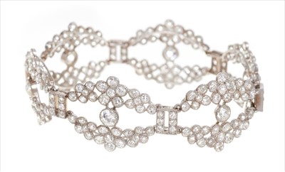 Lot 394 - Art Deco diamond bracelet comprising six openwork panels, each with a principal old cut diamond and floral clusters of further old cut diamonds, all in mille grain setting, in fitted box. Length ap...