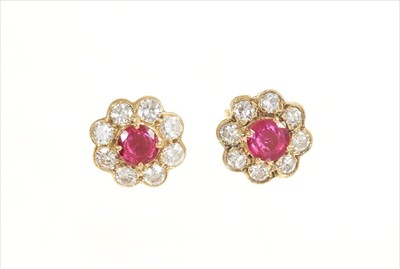 Lot 492 - Pair of ruby and diamond earrings, each flower head cluster with a central round mixed cut ruby surrounded by a border of eight brilliant cut diamonds in gold setting. 9.7mm diameter