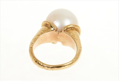 Lot 484 - Cultured pearl ring with a large single cultured pearl measuring approximately 12.8mm diameter in gold setting of organic modernist form with hammered finish. Signed 'Bagge', probably Eric Bagge (1...