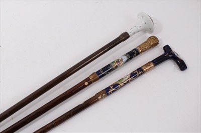 Lot 715 - Late 19th century Continental porcelain mounted walking stick, with embossed ormolu handle and Sevres style porcelain collar with figural reserve, tapering bamboo shaft, together with two similar s...