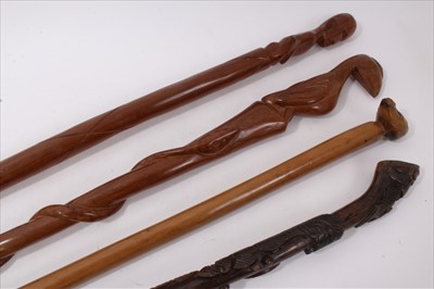 Lot 734 - 19th century carved hardwood tribal stick, together with three further carved wooden sticks