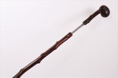 Lot 754 - Antique wooden sword walking stick, with club handle and naturalistic finish, 86cm long