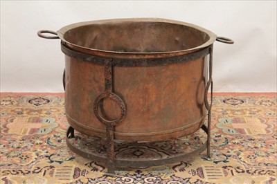 Lot 1357 - Old copper copper with two handles in a wrought iron stand, 60cm diameter x 47cm high