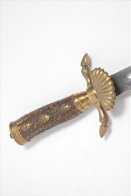 Lot 757 - 1930s German hunting Association sidearm with stag horn grip and brass acorn and hoof terminals , shell guard,saw back blade by Carl Eickhorn,Solingen in brass mounted leather scabbard.