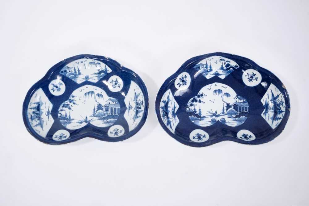 Lot 23 - Pair of Bow blue and white kidney-shaped dishes, circa 1760, the central panel painted with a fisherman, on a powder blue ground with further panels