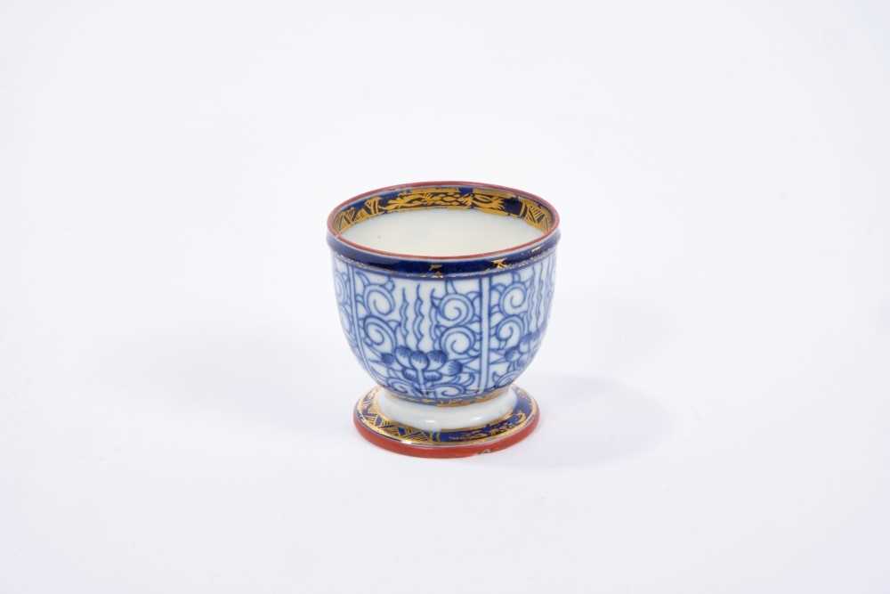 Lot 28 - Rare Caughley egg cup, circa 1785, painted in blue with the Lily pattern, gilt highlights, enamel painted rims, and 'S' mark to base, 4.25cm height