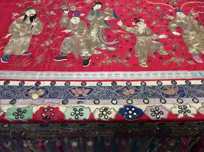 Lot 1640 - Chinese embroidered and mirrored large red silk panel c.1900s with couch and satin stitch figures, symbols, blossom and calligraphy. Embroidered silk borders with knotted fringing and tassels.