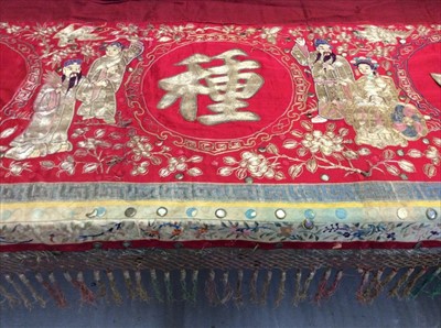 Lot 1642 - Chinese large embroidered and mirror-work red silk panel c19th century couch and satin stitch figures,  flowers, birds and butterflies also appliquéd symbols etc. Lined with red linen with fringing...