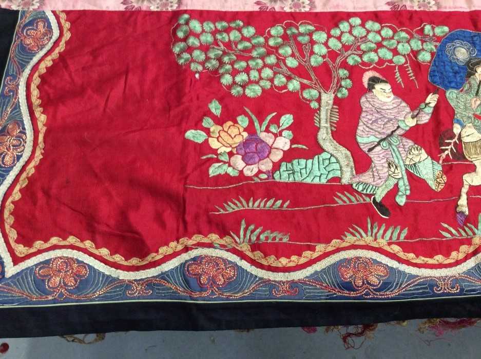 Lot 1649 - Chinese long embroidered red silk panel c19th century couch and satin stitch figures in garden scene with pagoda and horses etc. Lined with Chinese floral printed cotton with fring...