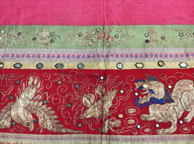 Lot 1654 - Chinese embroidered and mirrored red silk panel c.19th century with couch and satin stitches, lion, pheasant. Embroidered and woven silk borders with knotted and beaded fringing with tassels. Possi...