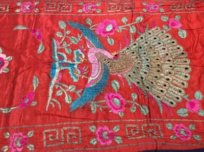 Lot 1656 - Chinese embroidered red silk vertical banner c1900s. Couch and satin stitches. Large peacock and flowers, scrolling foliage and flower border. Lined in blue cotton.