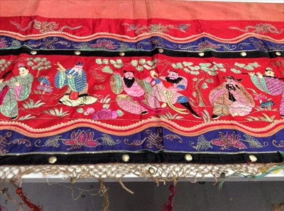 Lot 1660 - Chinese long embroidered red silk panel c19th century, couch and satin stitch musicians in garden scene etc. Embroidered silk border, red cotton lining. Knotted fringe with metal disc beads