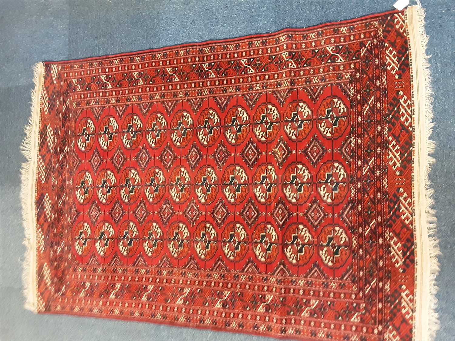 Lot 1072 - Eastern rug with geometric decoration on red ground