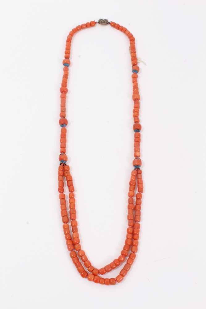Lot 3 - Old Chinese coral necklace, six of the barrel beads flanked by blue enamel flowers terminating with a double row of coral beads and an oval silver clasp