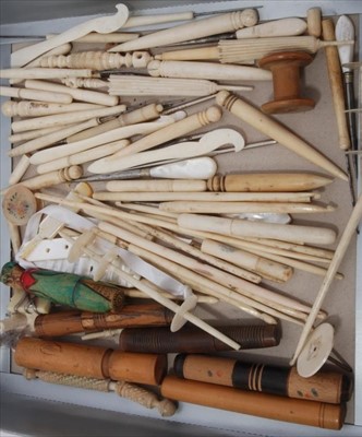 Lot 1683 - A collection of antique sewing items, carved bone needles cases including umbrellas, hooks and winders. Turned wood needle cases and bobbins with spangles.