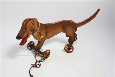 Lot 1354 - Articulated pull along model of a Dachshund dog, hand painted with wooden wheels