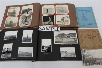Lot 1202 - A box of mixed ephemera including military scraps, family photographs, autograph album, cigarette cards etc.