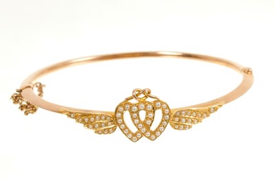 Lot 401 - Late Victorian gold and seed pearl hinged bangle with entwined hearts