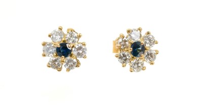 Lot 496 - Pair of sapphire and diamond flower head cluster earrings, each with a round mixed cut blue sapphire surrounded by brilliant cut diamonds. Estimated total diamond weight approximately 0.80 carat. D...