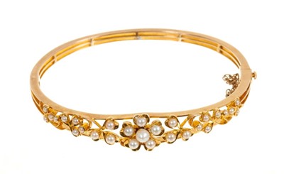 Lot 461 - Late Victorian gold and seed pearl hinged bangle with flower head and cloverleaf openwork design