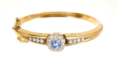 Lot 472 - Antique sapphire and diamond hinged bangle, the central flower head cluster with a cushion cut cornflower blue sapphire estimated to weigh approximately 2.20 carats surrounded by nine old cut diamo...